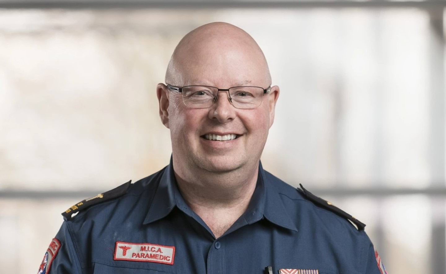 Professor Tony Walker ASM smiling in his Ambulance Victoria paramedic uniform
